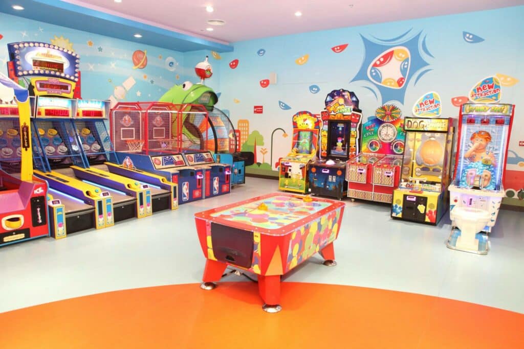 Uma sala com temática de criança, bem colorida, com diversos brinquedos de arcade infantil, em um local chamado FunCity, para representar o que fazer em Ras Al Khaimah