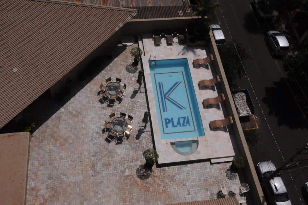 Vista aérea da piscina com algumas mesas e cadeiras em volta durante o dia, ilustrando post Hotéis em Barretos.