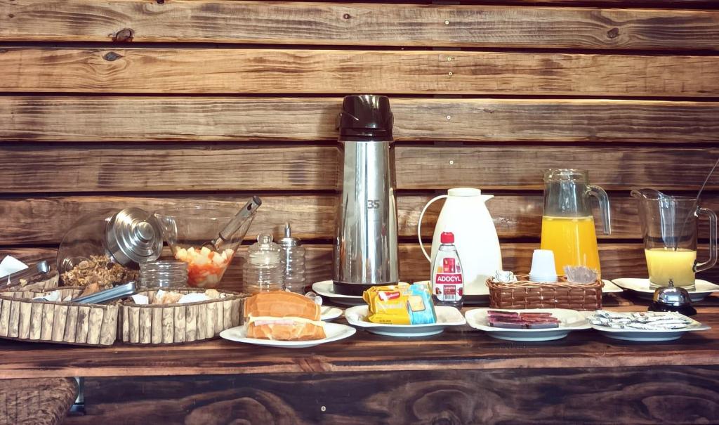Mesa com o café da manhã exposto e uma parede de madeira ao fundo, ilustrando post Hotéis em Barretos.