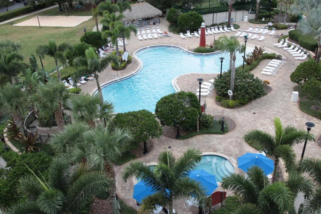 área externa do Calypso Cay Vacation Villas, um dos hotéis em Kissimmee, com duas piscinas, sendo uma maior de bordas sinuosas e outras melhores redondas com palmeiras e vegetação nos entornos