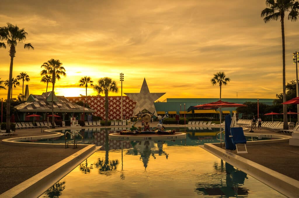 piscina ao pôr do sol com uma estrela grande no centro e mais detalhes temáticos, como o Donald, o Zé Carioca e o Pachito, no Disney's All-Star Music Resort