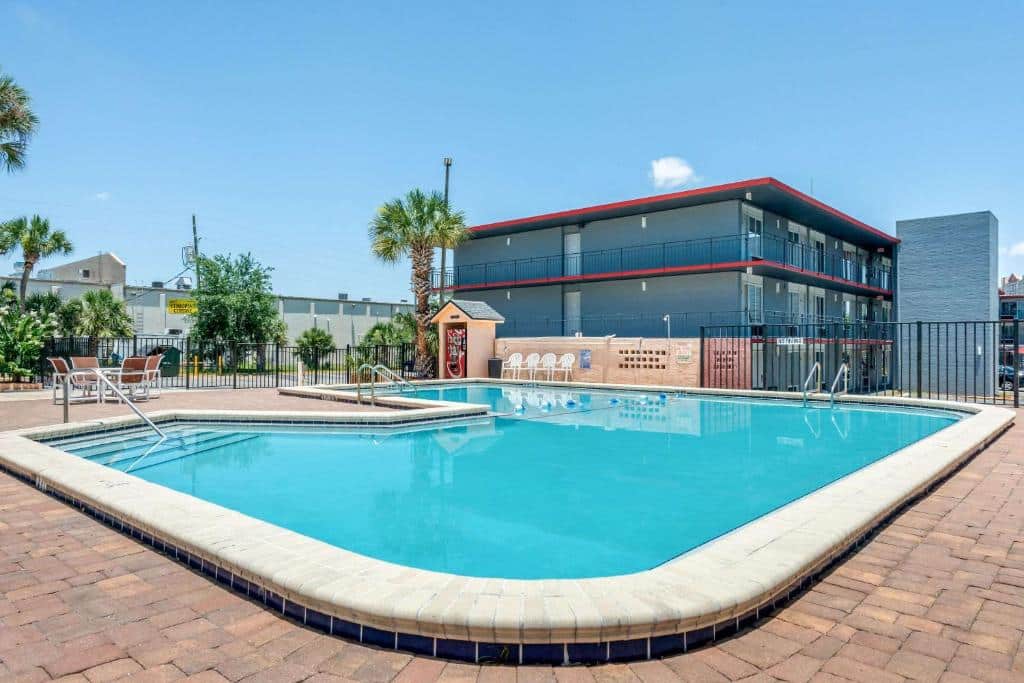 piscina com bordas arredondadas com a fachada atrás do Econo Lodge International Drive, um dos hostels em Orlando