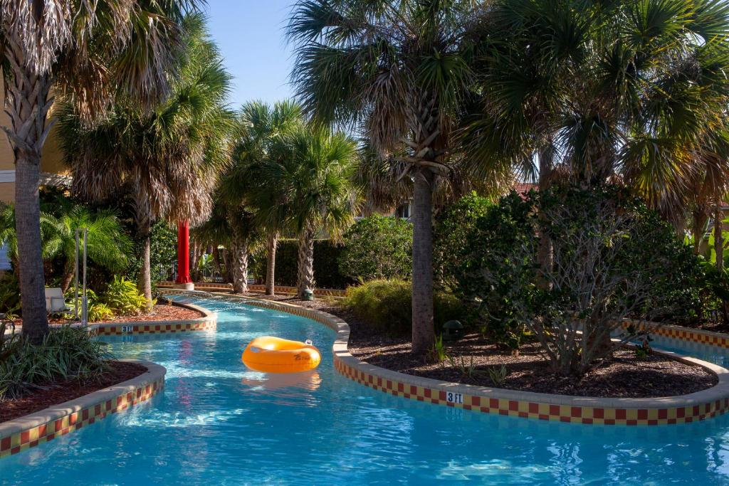 piscina cumprida com correnteza e uma boia amarela, rodeada por árvores no FantasyWorld Resort, um dos hotéis com cozinha em Orlando