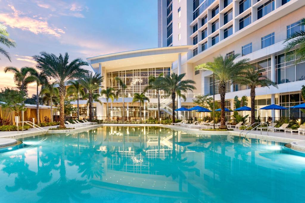 piscina com a fachada do hotel atrás no terraço com algumas palmeiras mais baixas no JW Marriott Orlando Bonnet Creek Resort & Spa, um dos hotéis perto da Disney