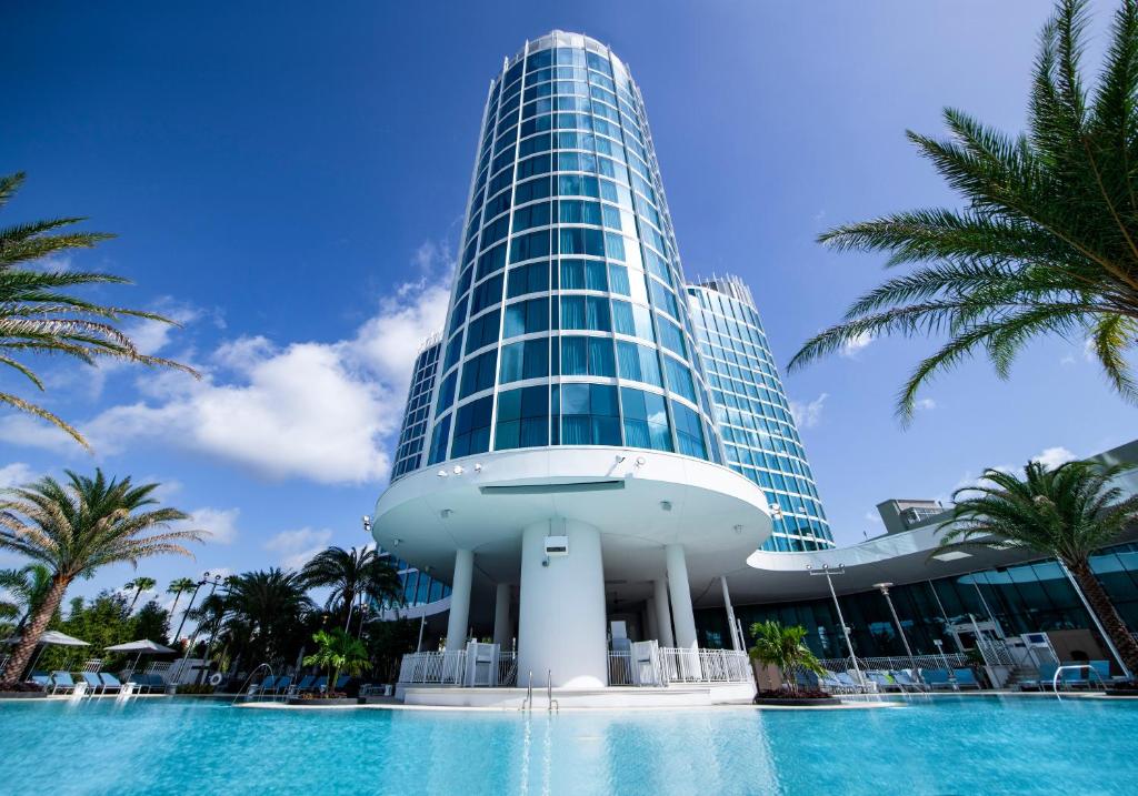 fachada alta e sinuosa repleta janelas e estilo vidrado com piscina abaixo do Universal's Aventura Hotel, um dos hotéis da Universal em Orlando