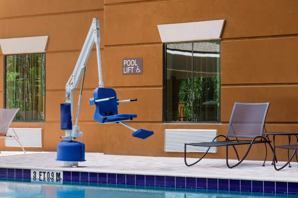 piscina com uma cadeira suspensa com um mecanismo para auxiliar pessoas com deficiência a entrarem na água no Candlewood Suites - Orlando - Lake Buena Vista, an IHG Hotel, um dos hotéis perto da Disney