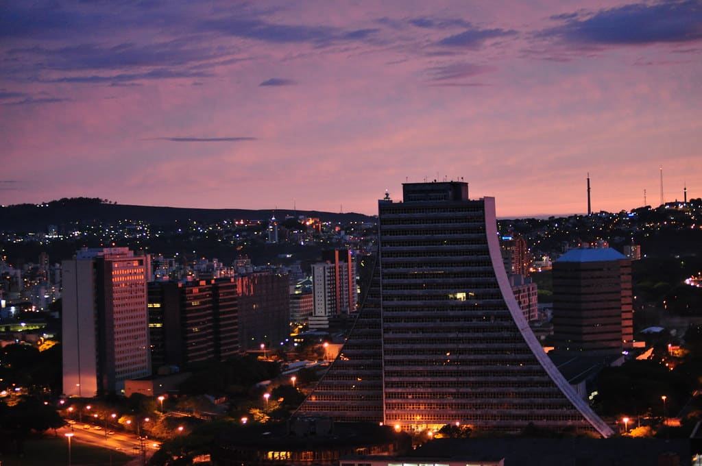 Entardecer em Porto Alegre, céu rosado e prédios iluminados. Para ilustrar post sobre Hotéis perto do Consulado Americano em Porto Alegre.