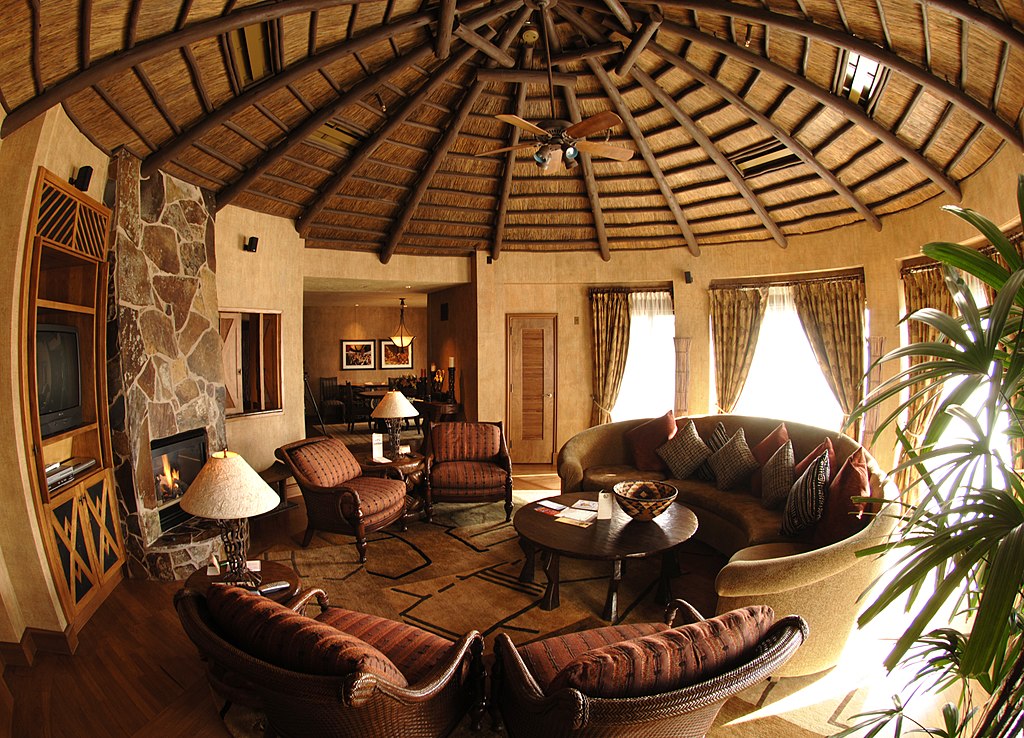 quarto com sofás imitando uma tenda trabalhada em madeira com poltronas em tons terrosos marrons no Disney's Animal Kingdom Lodge
