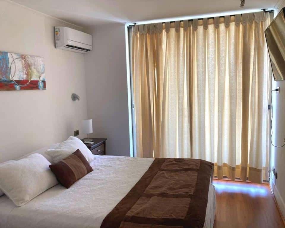 Quarto do Departamentos Apartviews Cordillera com cama de casal do lado esquerdo, uma cômoda do lado esquerdo do quarto e uma TV em frente a cama.
