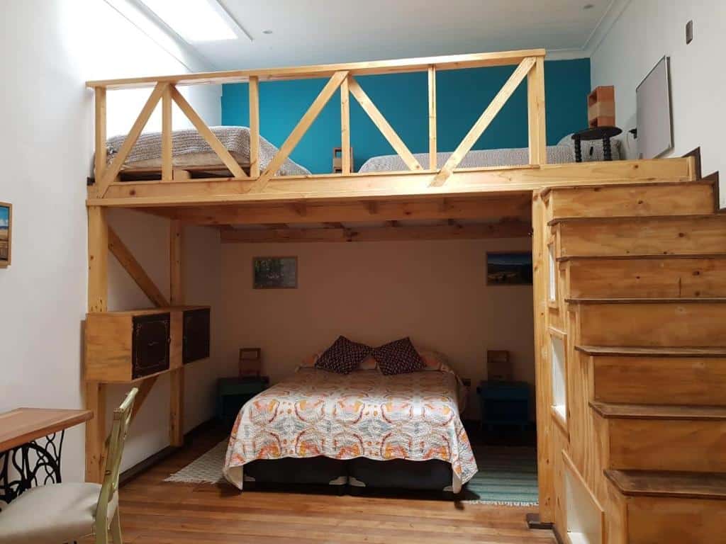 Quarto do Eco-Hostal Tambo Verde com cama de casal embaixo do lado esquerdo uma escada de madeira que dá acesso ao andar superior que têm duas camas solteiro.