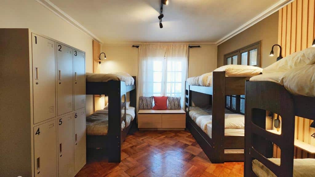 Quarto compartilhado do Yogi Hostel com três camas beliches no ambiente e um armário do lado esquerdo.
