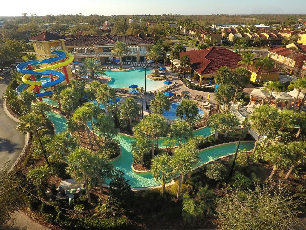 vista da fachada com piscina e um alto tobogã que segue uma corrente de uma outra piscina bem comprida que cerca o FantasyWorld Resort, um dos hotéis em Kissimmee