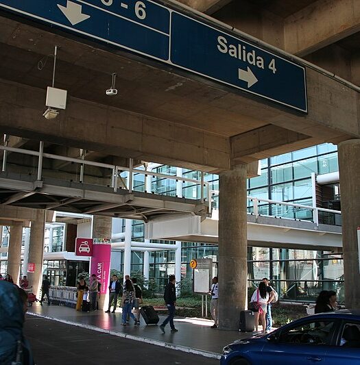 Terminal do aeroporto de Santiago com pessoas em volta durante o dia. Representa aluguel de carro no aeroporto de Santiago.