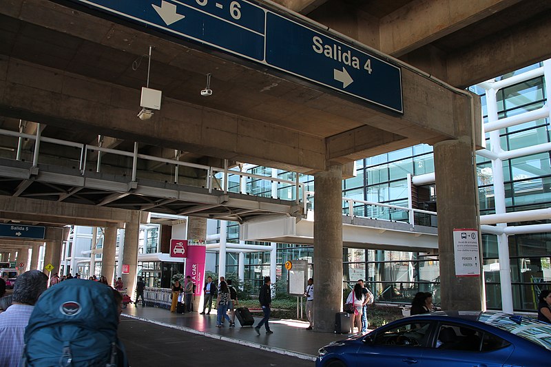 Terminal do aeroporto de Santiago com pessoas em volta durante o dia. Representa aluguel de carro no aeroporto de Santiago.