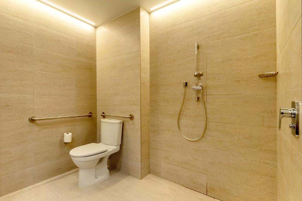 Banheiro com mobilidade do Hyatt Centric Las Condes com vaso sanitário do lado esquerdo com barra de segurança e piso plano.