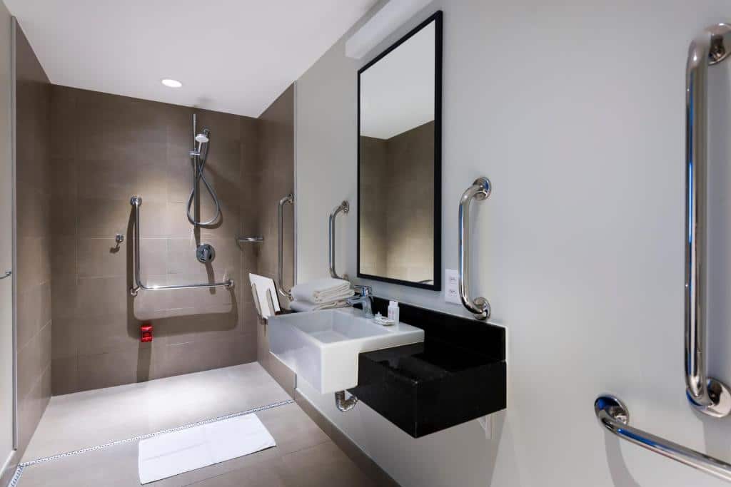 Banheiro do hotel com barras de apoio e outros recursos para mostrar a acessibilidade.