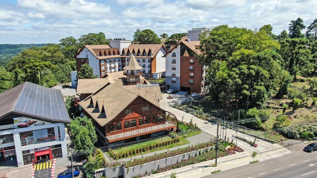 vista aérea do Bella Gramado Resort & Spa by Gramado Parks mostrando quatro grandiosas construções em estilo bechamel, com jardins e ruas perpassando entre elas.