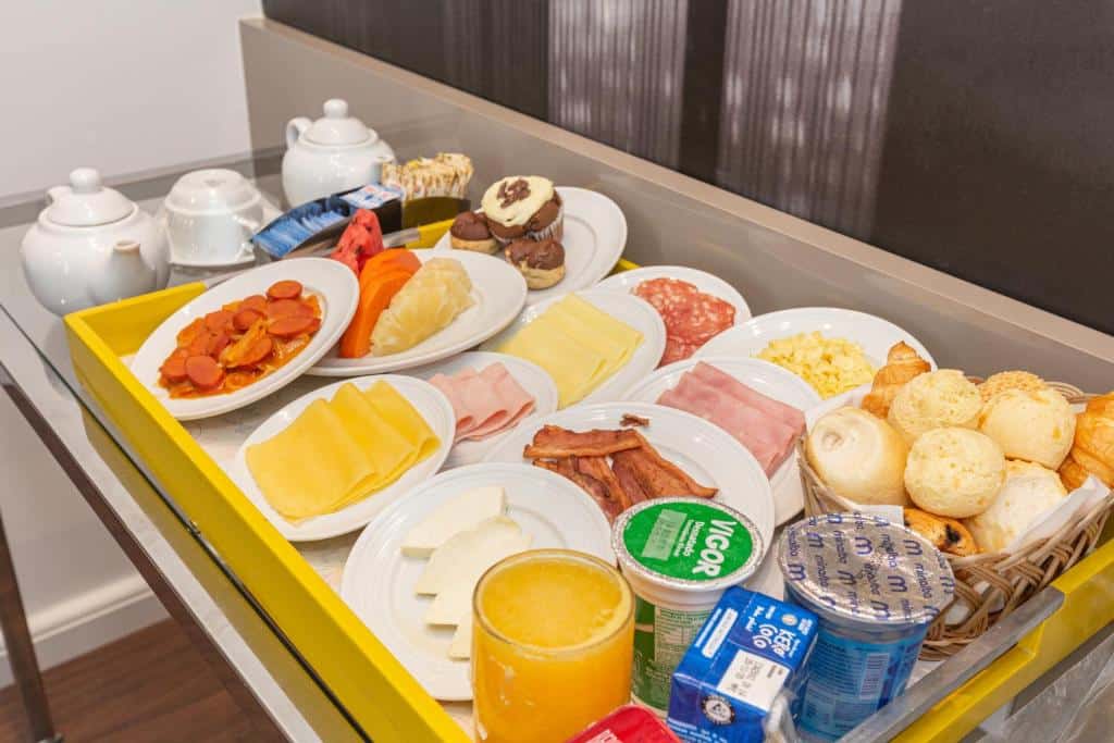 Uma bandeja de café da manhã, com frutas, frios, suco, água e pão. Foto para ilustrar post sobre hotéis perto do Hospital Albert Einstein.
