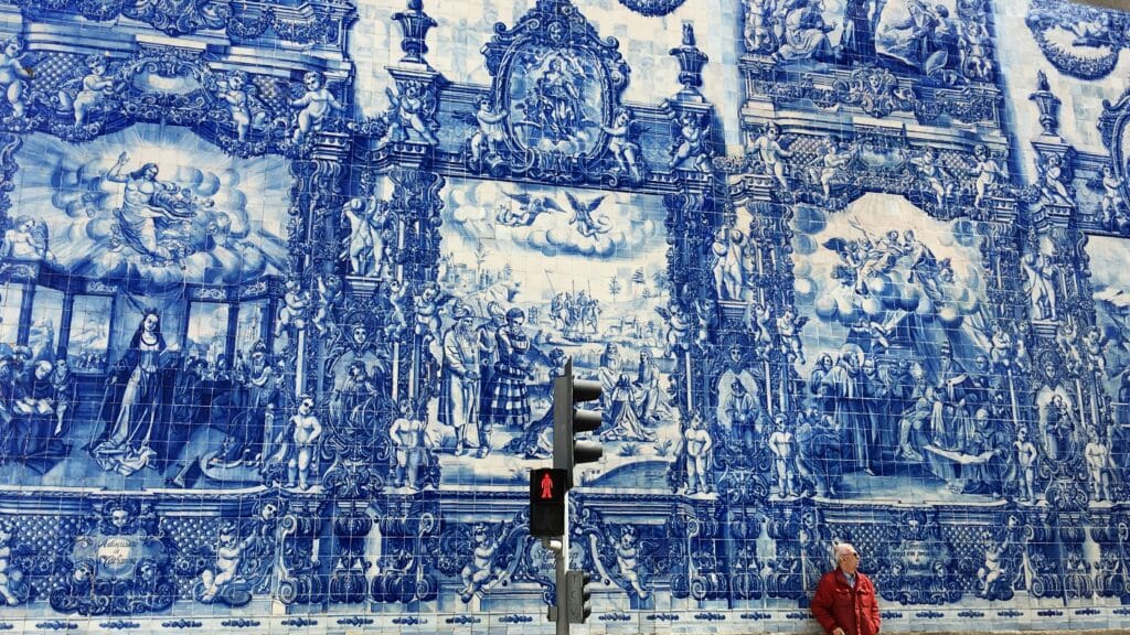 Vista da Capela de Santa Catarina e Senhora dos Anjos, Largo Santa Catarina, durante o dia com decoração de azulejos azuis com imagens santas durante o dia e um senhor a frente.