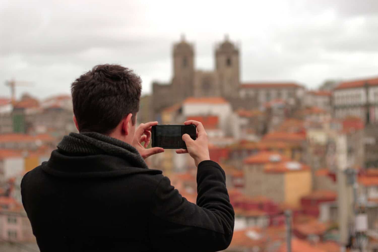 Homem tirando foto em Porto durante o dia. Representa chip celular Porto.
