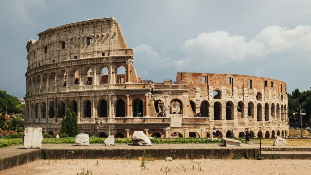fachada do Coliseu, em Roma, sendo uma estrutura com arcos arredondados