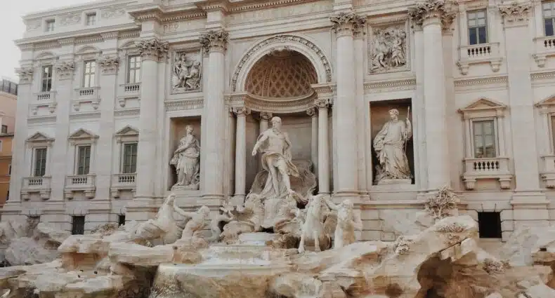 A Fontana di Trevi, em Roma, Itália, com esculturas ornamentadas e água corrente, em um cenário arquitetônico grandioso.