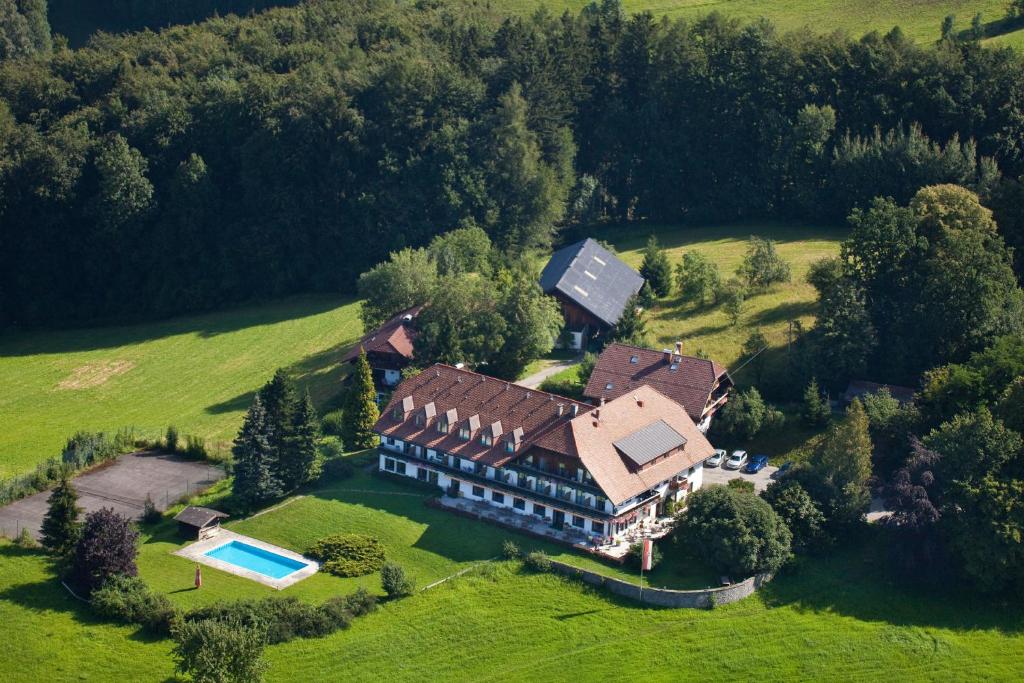 Foto aérea do hotel com uma piscina ao lado, gramado verde e várias árvores ao redor durante o dia, ilustrando post Hotéis em Salzburg.