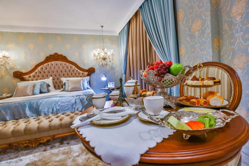 Café da manhã em cima de uma pequena mesa em um quarto de hotel luxuoso com decoração temática de Paris.