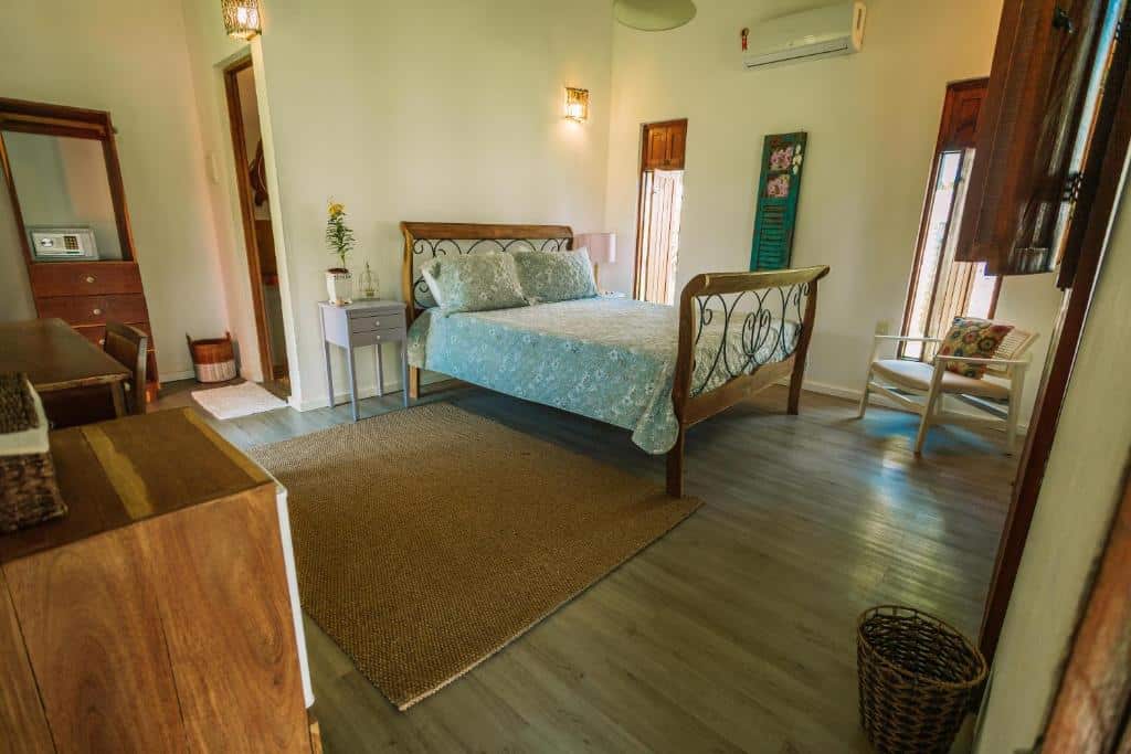 Quarto de casal no Ocacocar, com cama de casal, mesinha de cabeceira, ar-condicionado, cômodas e paredes claras