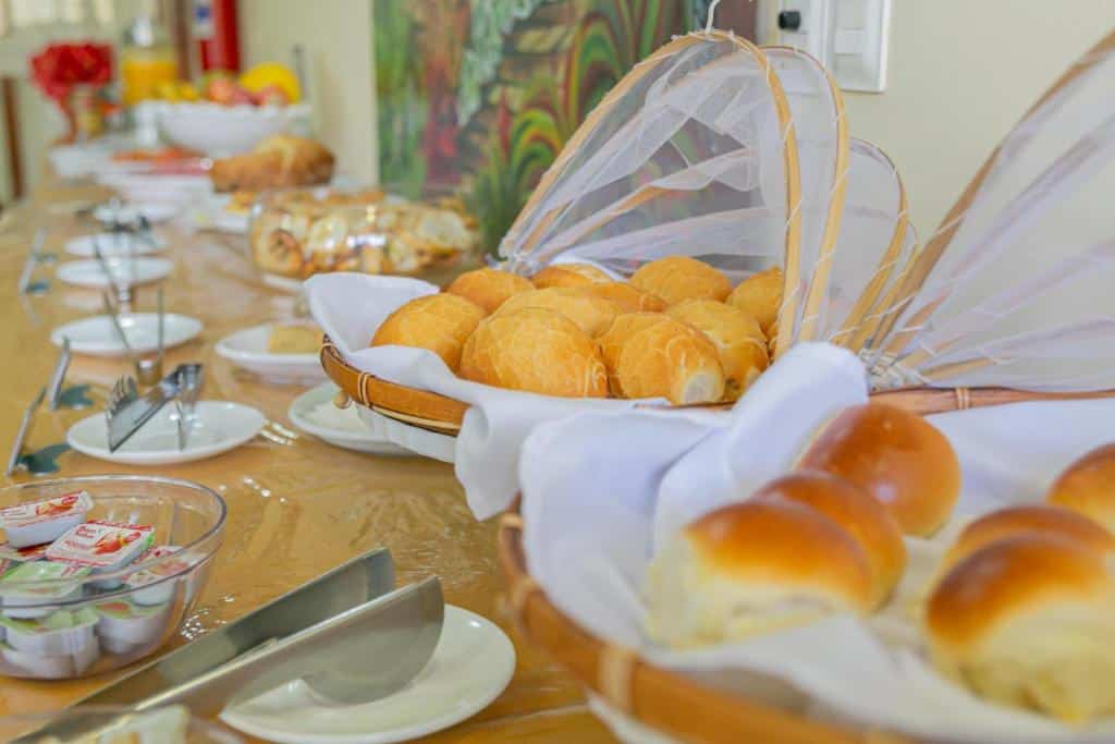 Mesa de café da manhã de hotel em Teresina com cestas de pães.