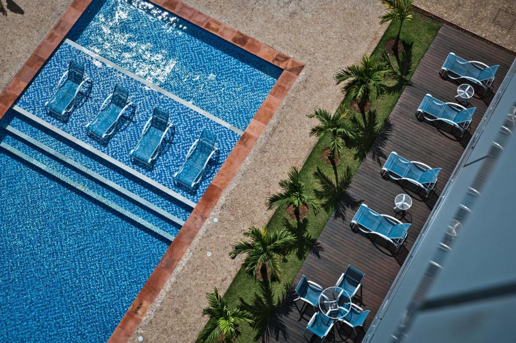 Vista de cima pra piscina, com cadeiras de tomar sol ao redor. Foto para ilustrar post sobre hotéis perto do Hospital Albert Einstein.
