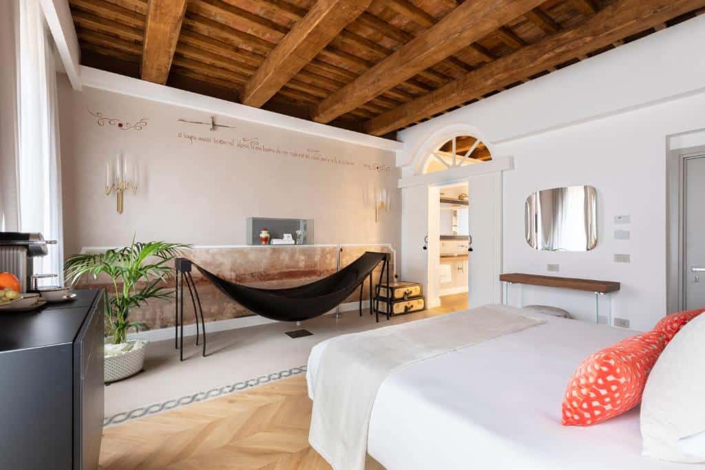quarto do Poēsis Experience Hotel, um dos hotéis boutique em Roma, com cama de casal, banheira preta toda diferentona, com espelho, teto de madeira e detalhes em laranja