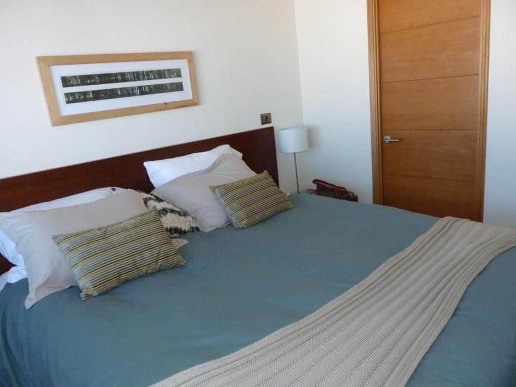 Quarto do Valle Nevado Apartamento Ski In Out com cama de casal com dois travesseiros.
