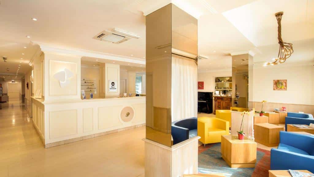 recepção do Best Western Hotel Globus em detalhes de amarelo e azul, com poltronas confortáveis, mesinhas e decoração clássica