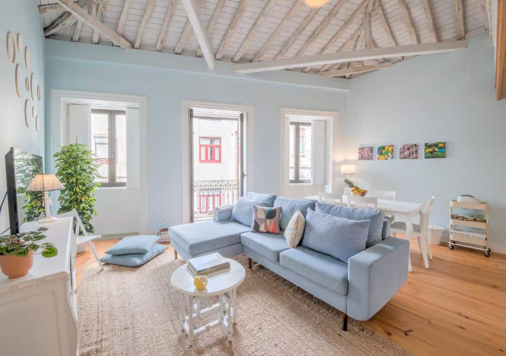 Sala do Look At Me - Serviced Lofts & Studios com sofá cor azul claro, a frente e uma mesa de centro branca. 
Representa Porto.