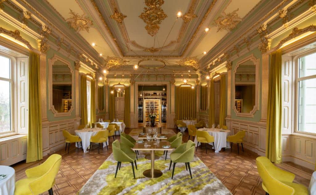 Sala de refeição do Vila Foz Hotel & SPA – member of Design Hotels com cadeiras e mesas.