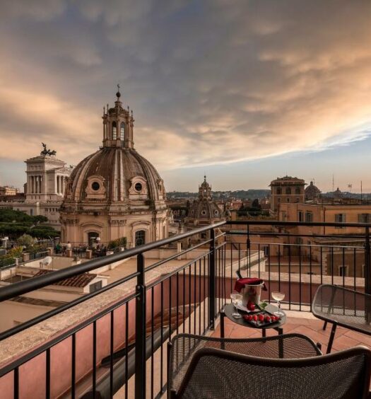 terraço com cadeiras confortáveis e uma mesinha com champanhe, a vista é para o Fórum Romano no H10 Palazzo Galla, uma das opções de onde ficar em Roma