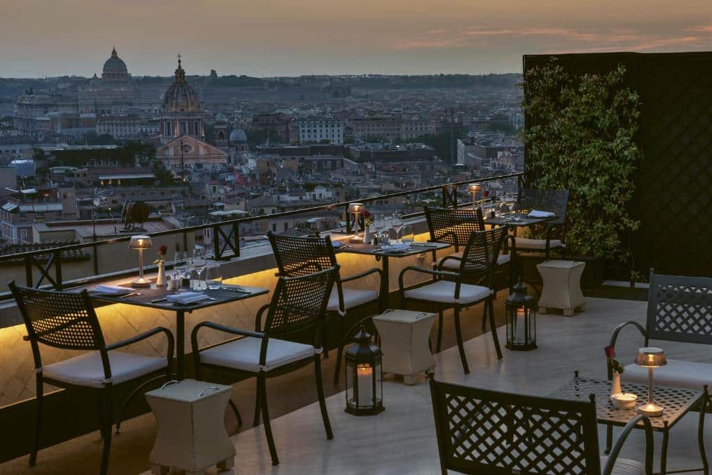 terraço do Hassler Roma com mesas e cadeiras à luz de velas com vista para a cidade