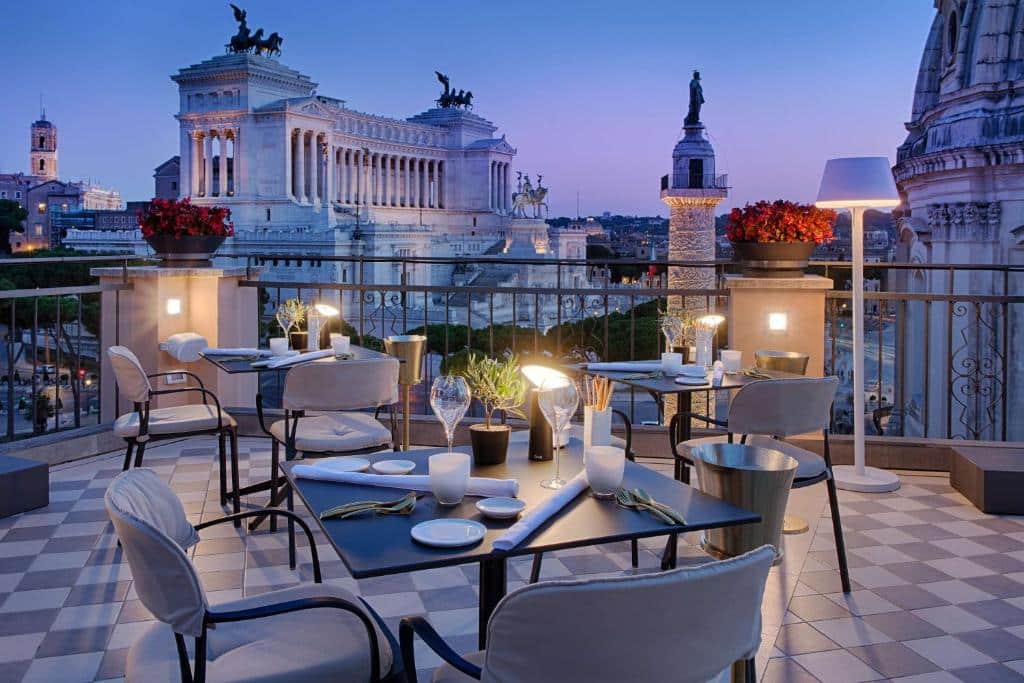 terraço do NH Collection Roma Fori Imperiali com vista para o Fórum Romano, há mesas com cadeiras confortáveis