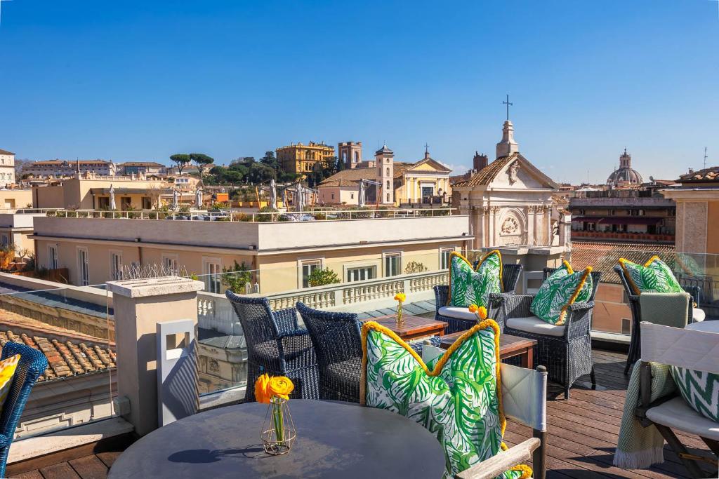 terraço do Singer Palace Hotel com mesa e cadeiras com almofadas coloridas e vista da cidade