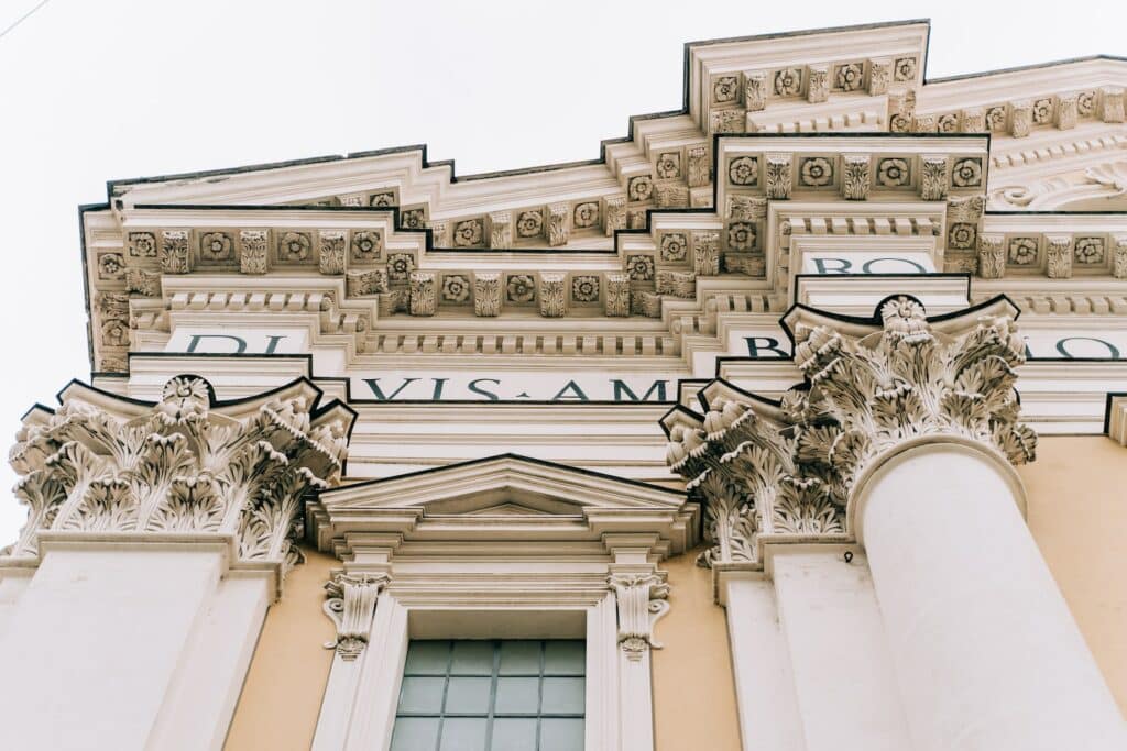 vista de um monumento com colunas e uma fachada muito trabalhada com vários detalhes na Via del Corso, uma das ruas mais movimentadas de Roma