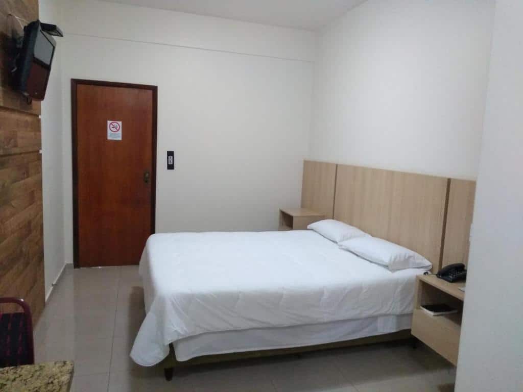 Quarto do Victoria Plaza Hotel com uma cama de casal, mesinhas de cabeceira e televisão. Foto para ilustrar post de hotéis em Palmas.