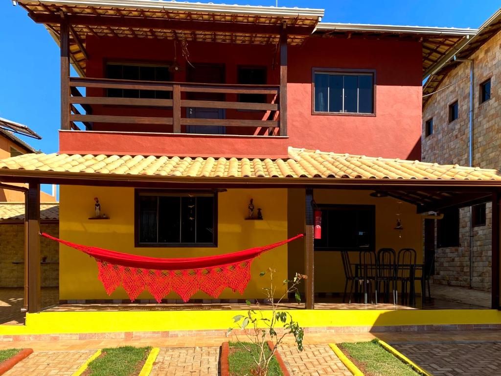 fachada de uma das casas da vila dos sonhos. A construção tem dois andares, com varanda coberta em cima e embaixo. A parte debaixo é pintada em amarelo, e em cima é pintado de vermelho queimado.