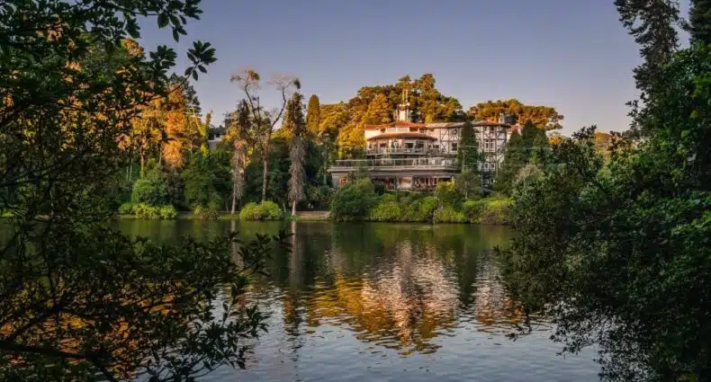 vista do entardecer no lago negro mostrando o sol batendo no hotel estalagem st hubertus