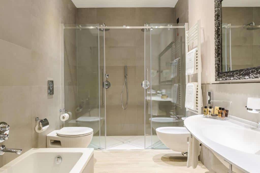 Banheiro espaçoso do Windsor Hotel Milano com uma box confortável, um vaso sanitário, banheira de hidromassagem e uma pia