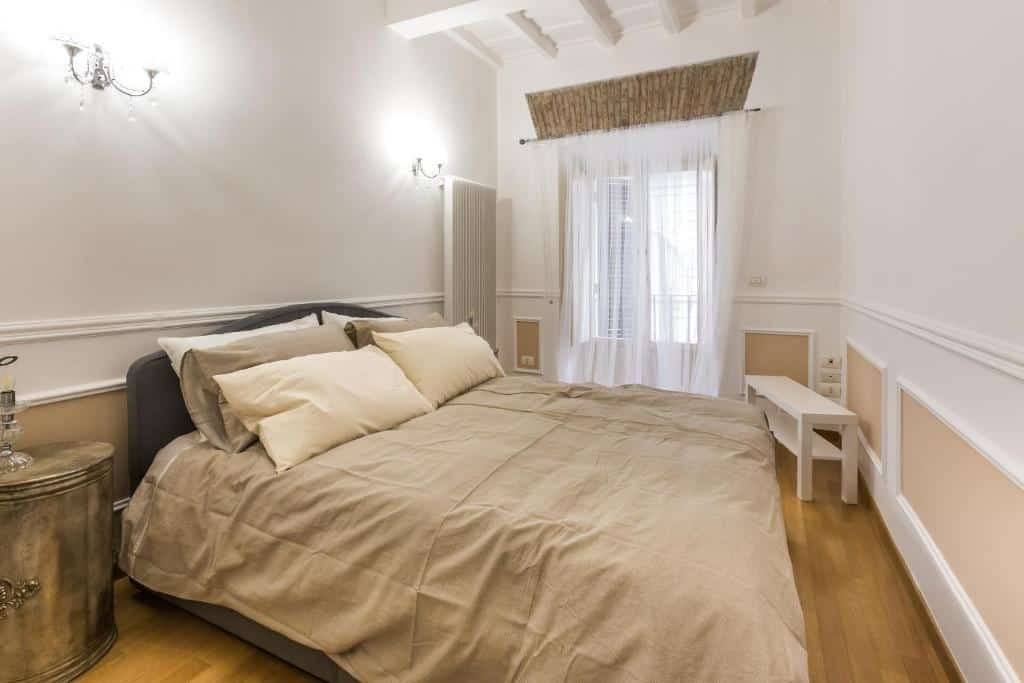 quarto do aluguel de temporada em Roma Castel Sant'Angelo Apartments - Exclusive & Luxury, com cama de casal, janela comprida com cortinas claras e um aparador