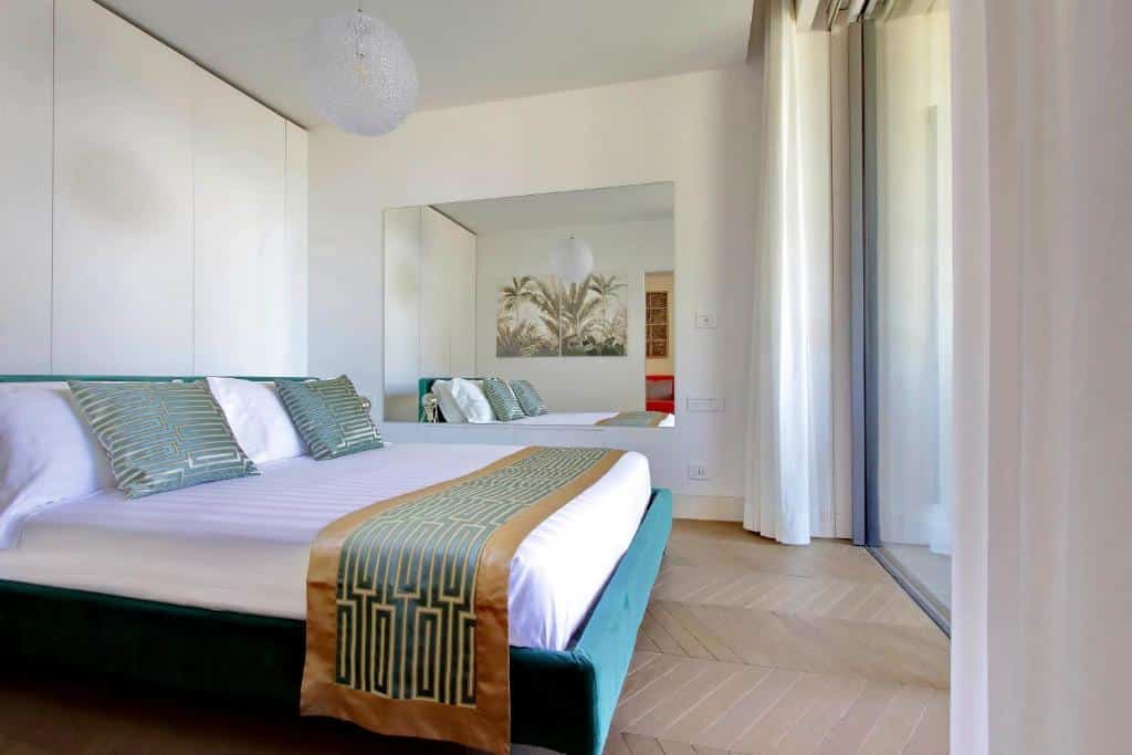 quarto do Luxury Domus Apartment 1, um aluguel de temporada em Roma, com cama de casal enorme com detalhes verdes e dourados, com uma grande janela com vista e detalhes nas paredes e um grande espelho