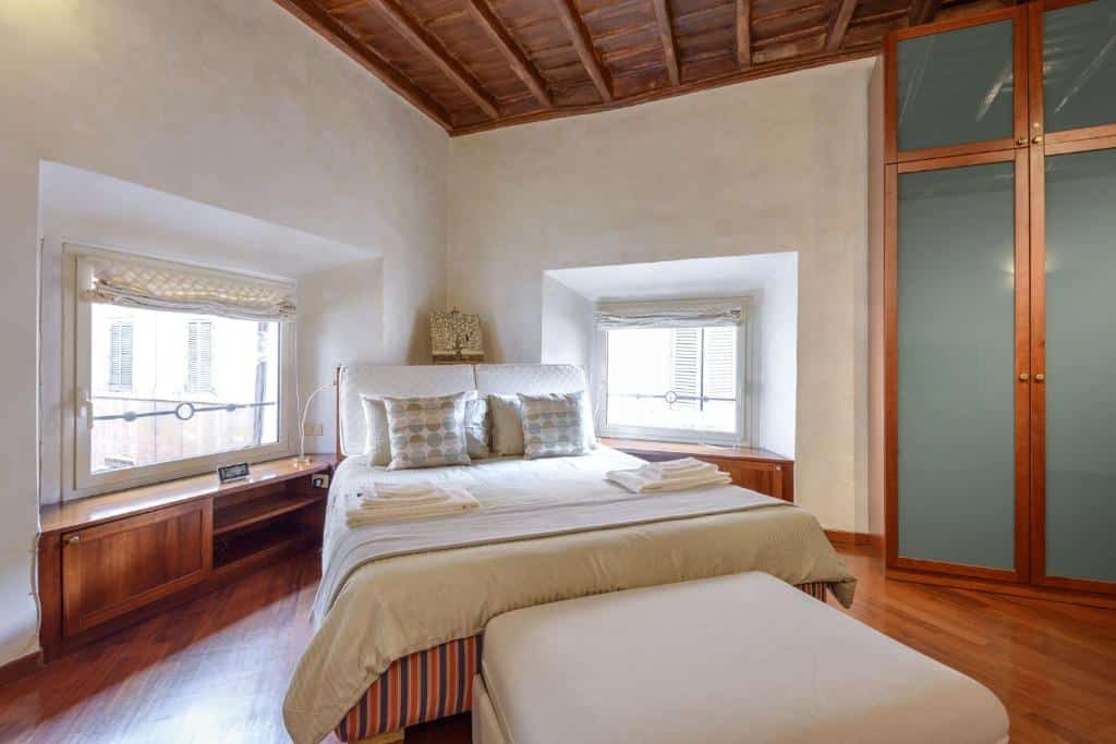 quarto do aluguel de temporada em Roam no Pantheon Palazzo Nari com cama de casal, cômoda, janelas quadradas e decoração simples com gaurda-roupa
