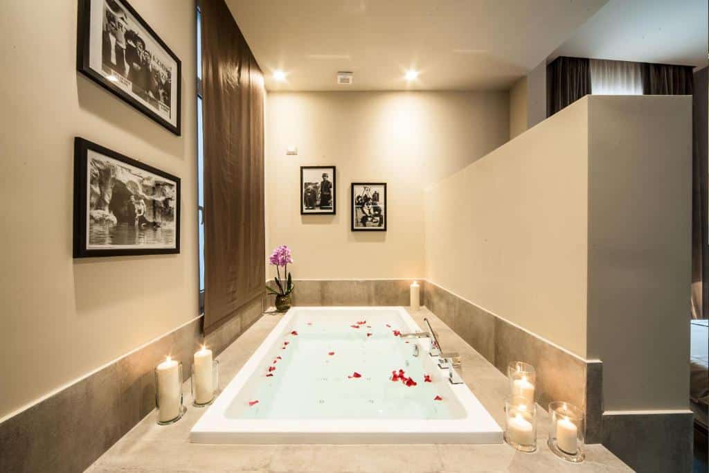 banheira de hidro no Vittoriano Luxury Suites retangular com pétalas de flores e velas ao redor