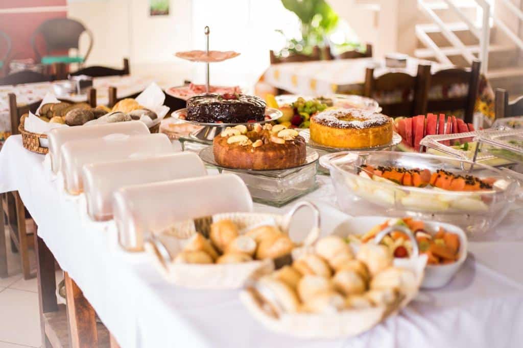Buffet do Pousada Pompeia, em Socorro. Na mesa podemos ver vários doces, frutas e bolos.
